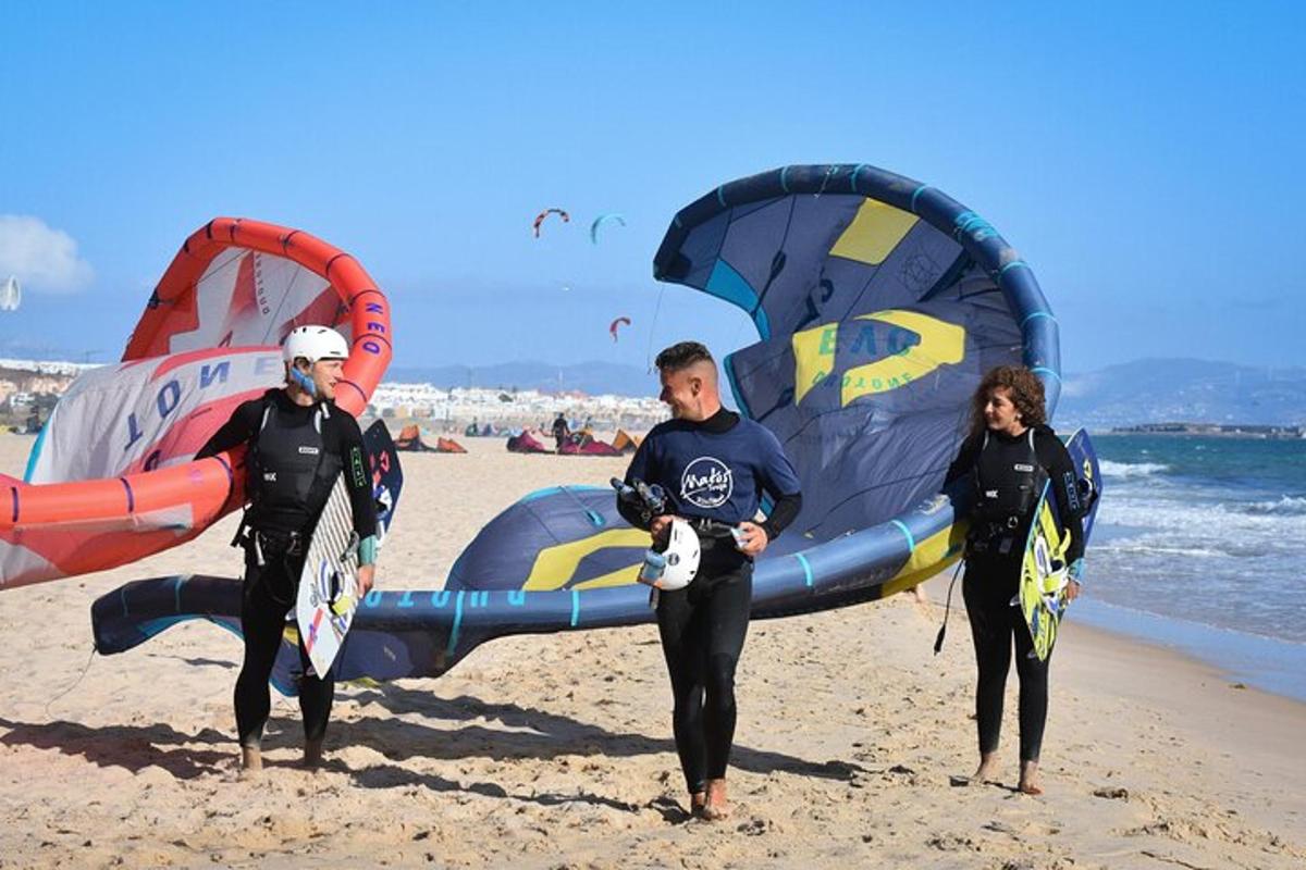 a group of people standing on a beach with a parachute