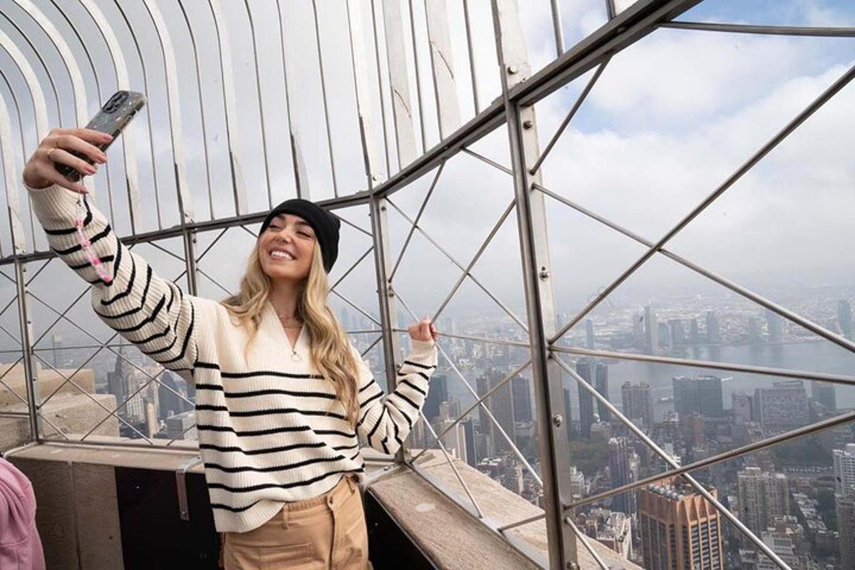 a woman is standing on the top of a glass tower