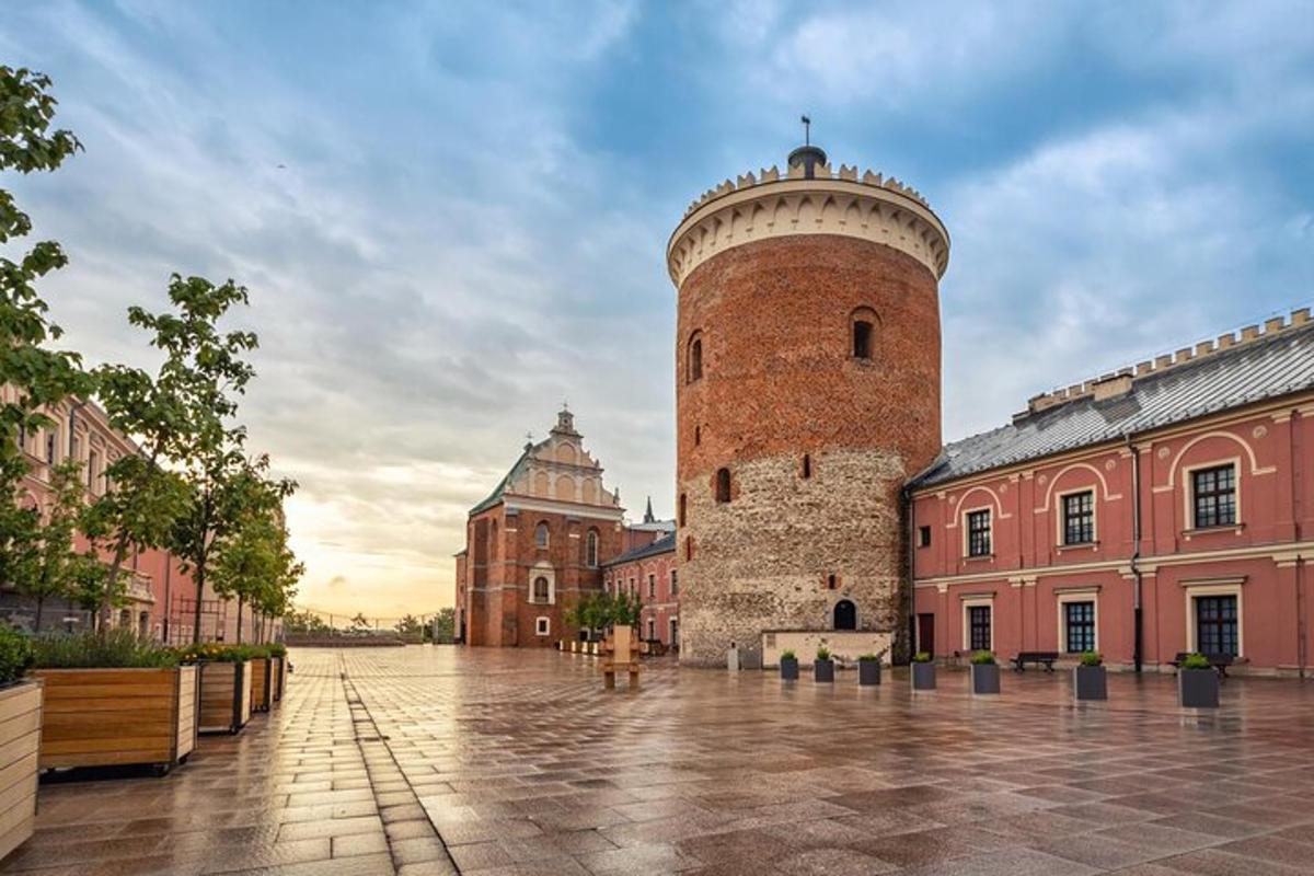 a large brick building with a tower in a courtyard