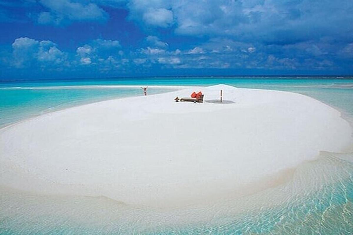 a white beach with a bench on top of it