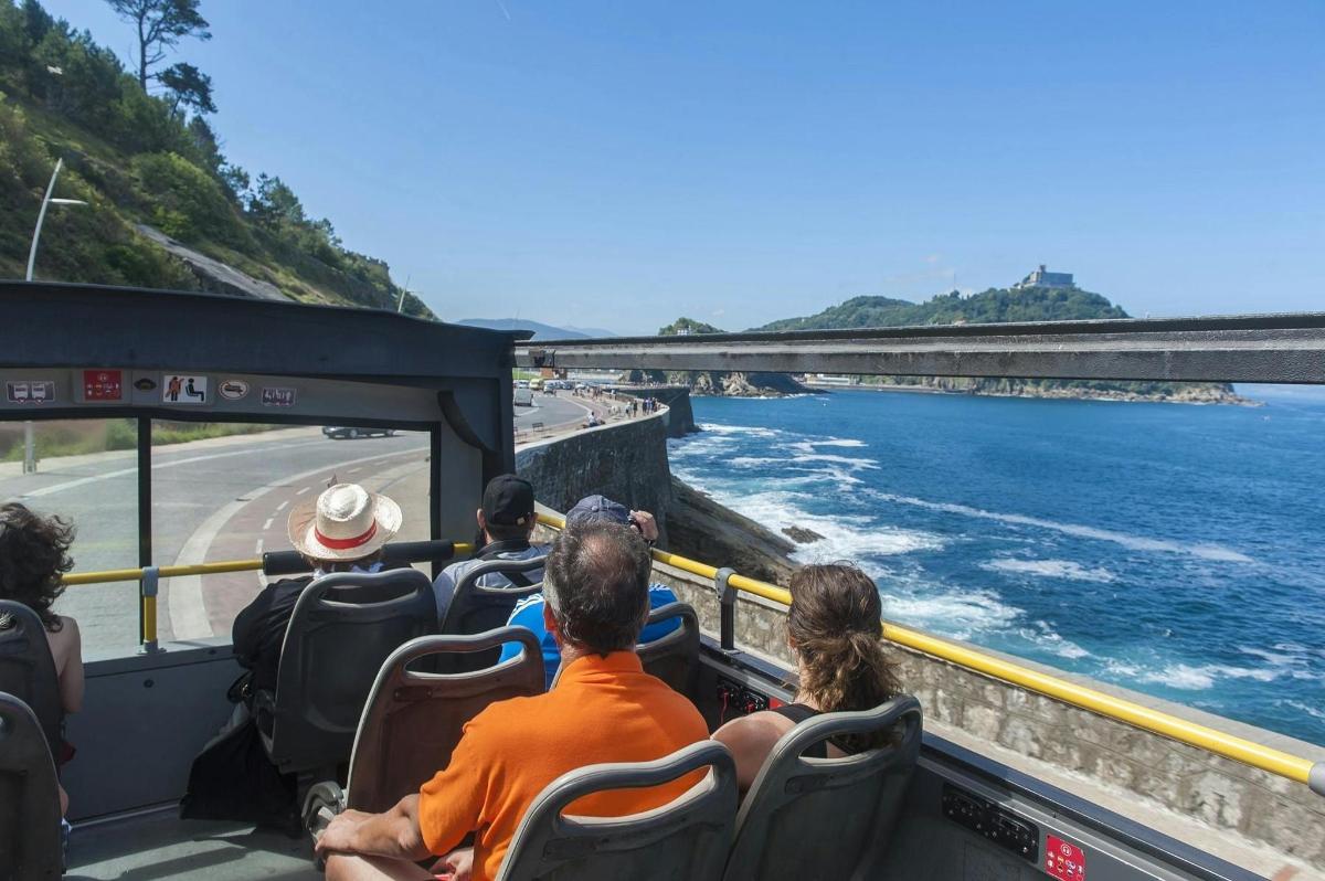 a group of people on a bus looking at the water