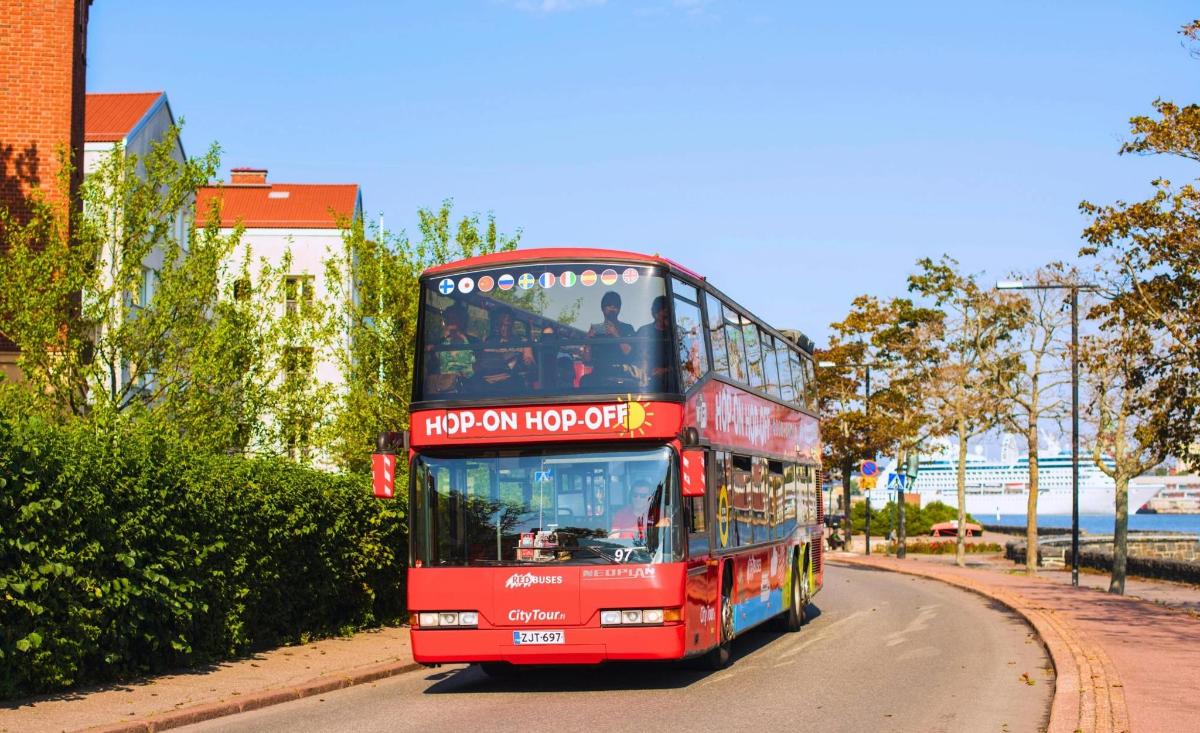 a red double decker bus driving down a street