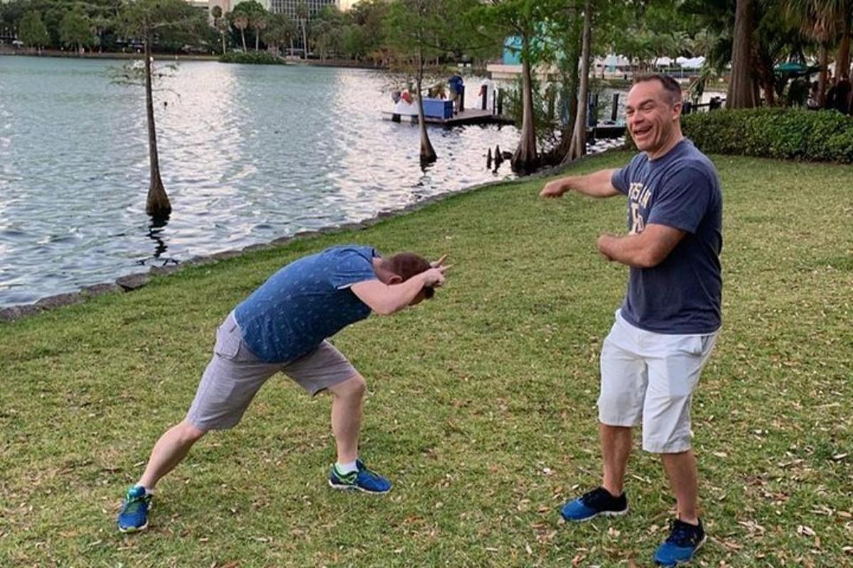 two people playing with a frisbee by the water
