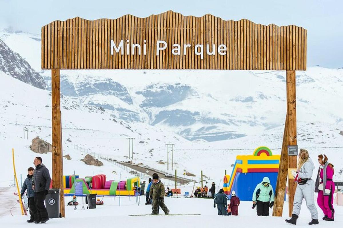 a sign at a ski slope with people in the snow