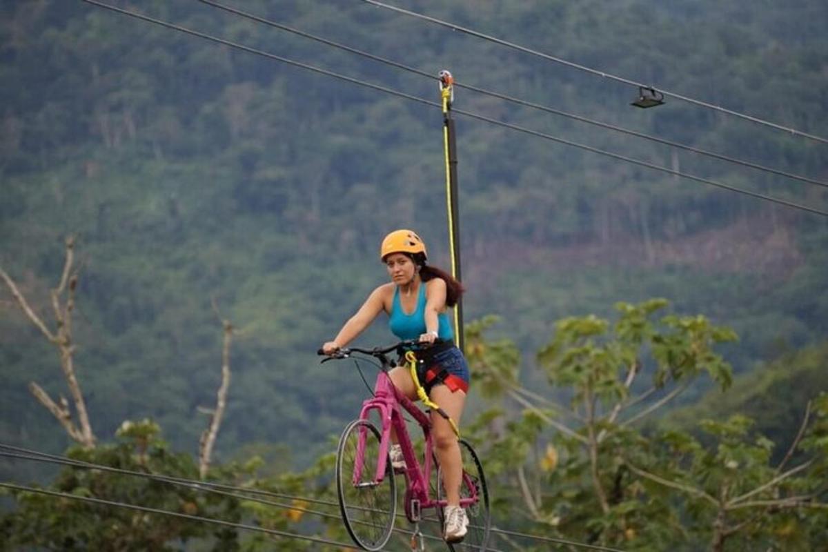 a woman riding a bike on a zip line