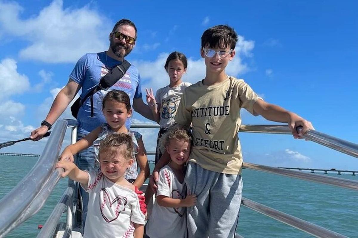 a group of children standing on a boat in the ocean