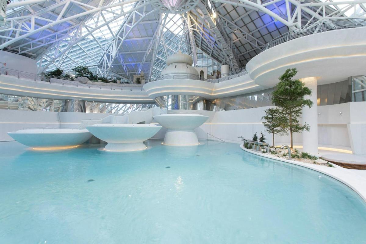 a large swimming pool in a building with a water slide