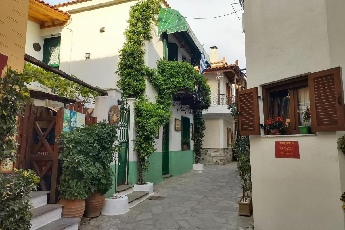 an alley with plants on the side of a building