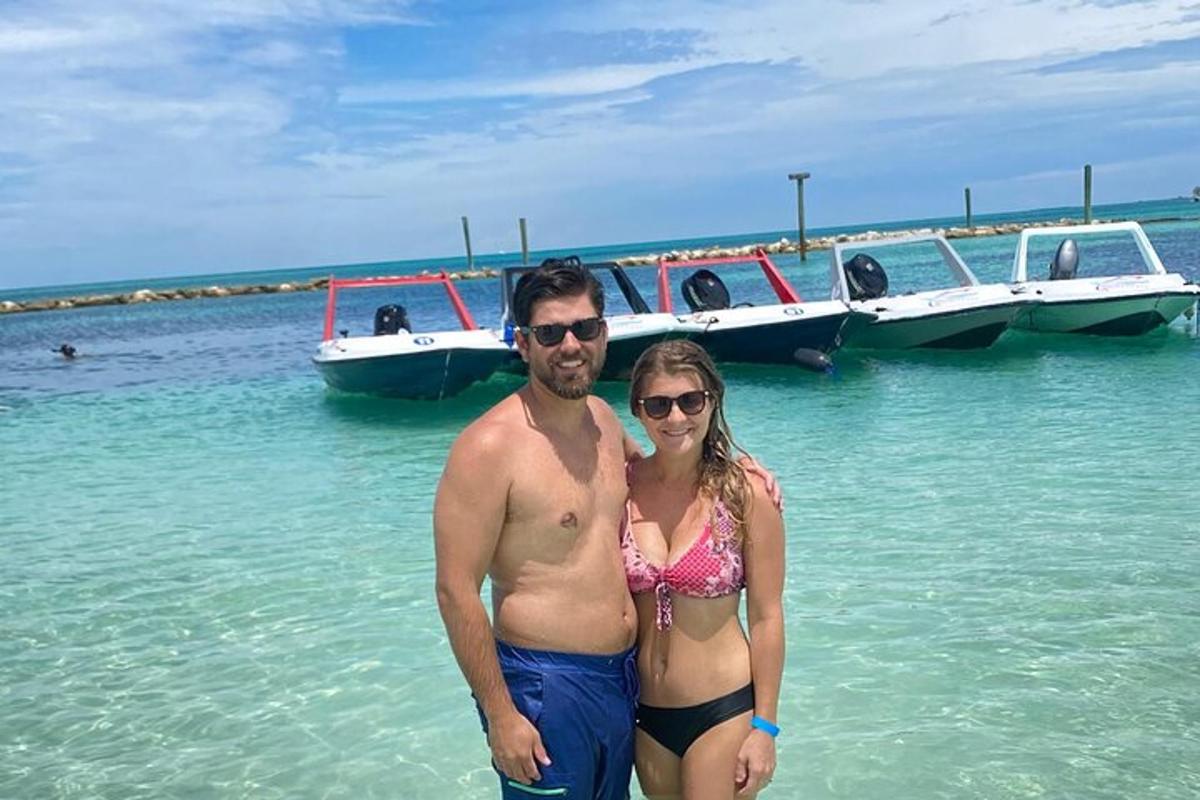 a man and a woman standing in the water with boats