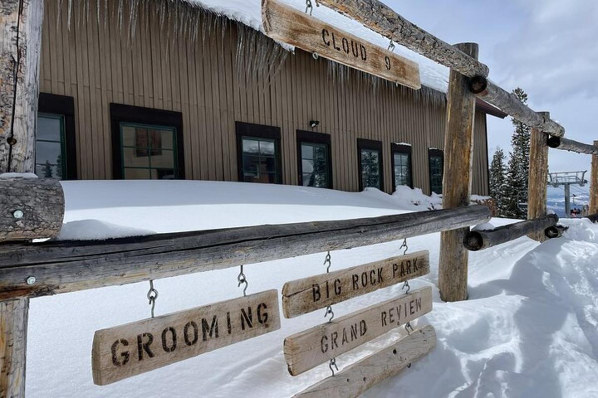 a wooden fence in the snow in front of a building