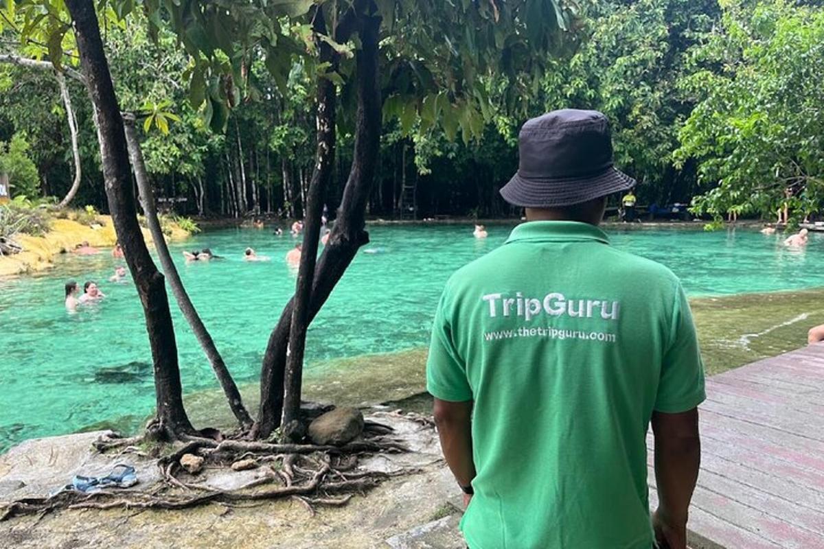 a man in a hat standing next to a body of water