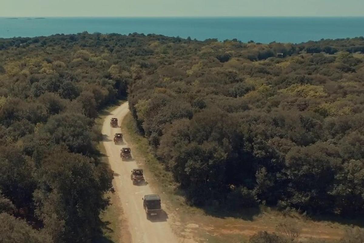 skupina nákladních aut jedoucích po nezpevněné cestě