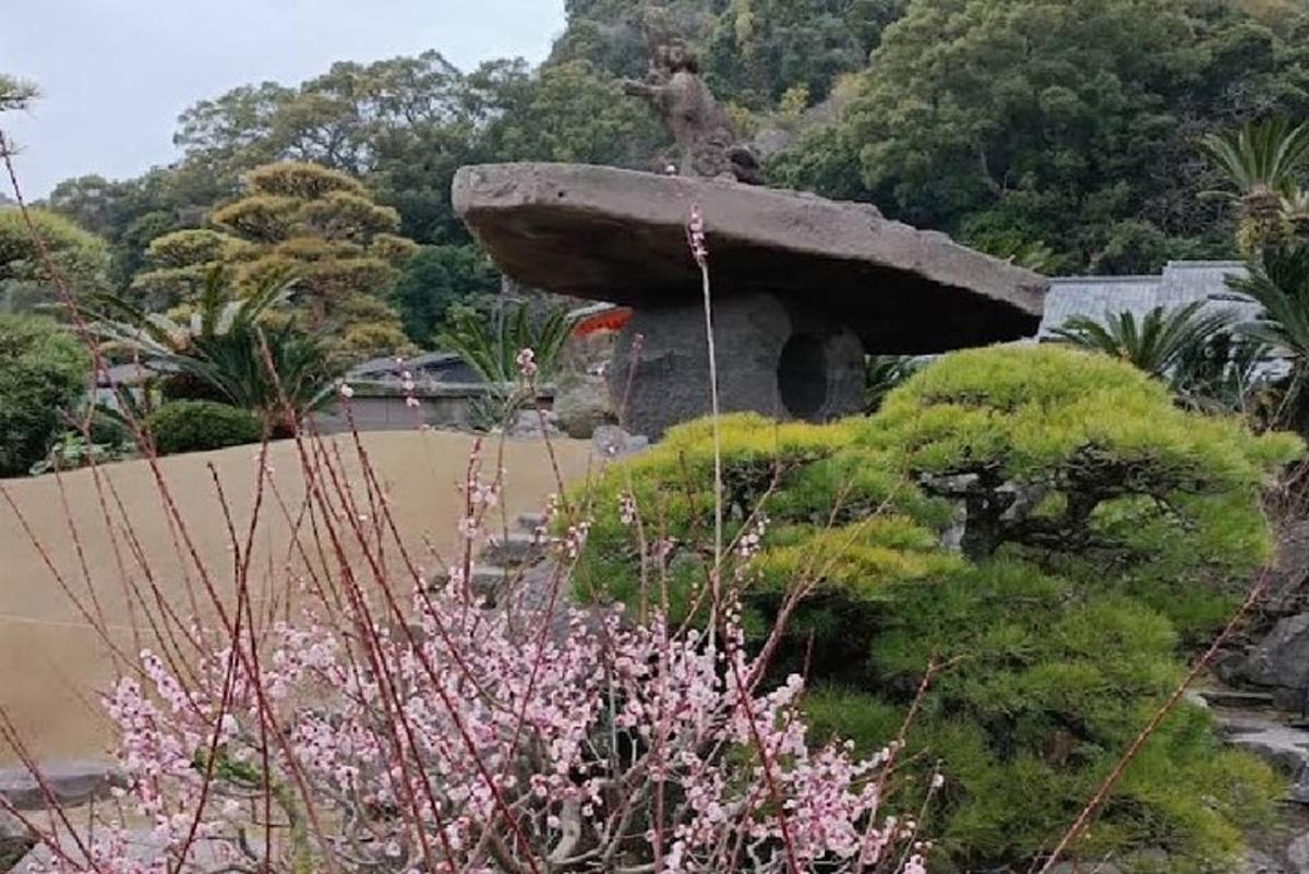 a garden with a stone fountain and trees