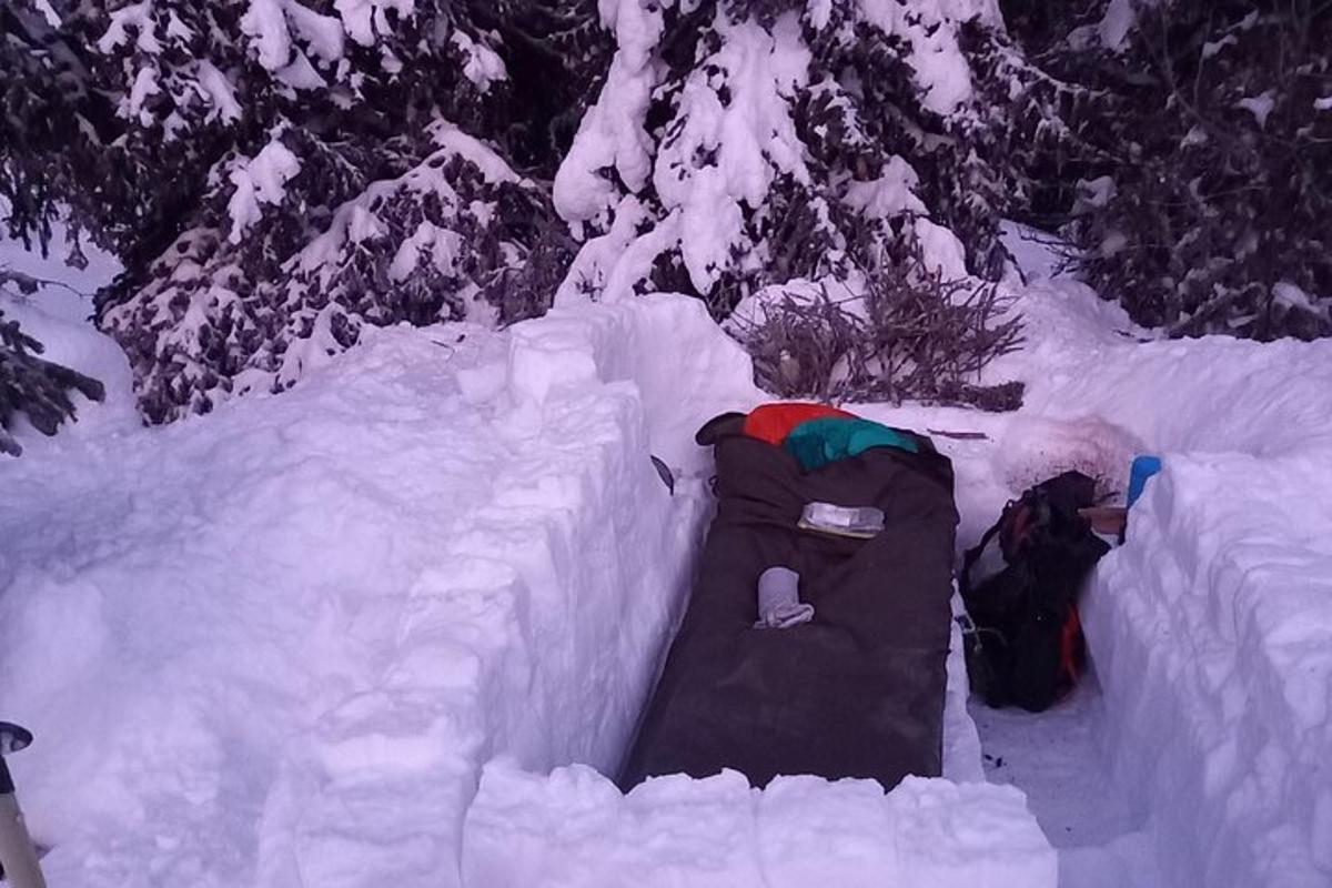 a snow covered fence with a sleeping bag in the snow
