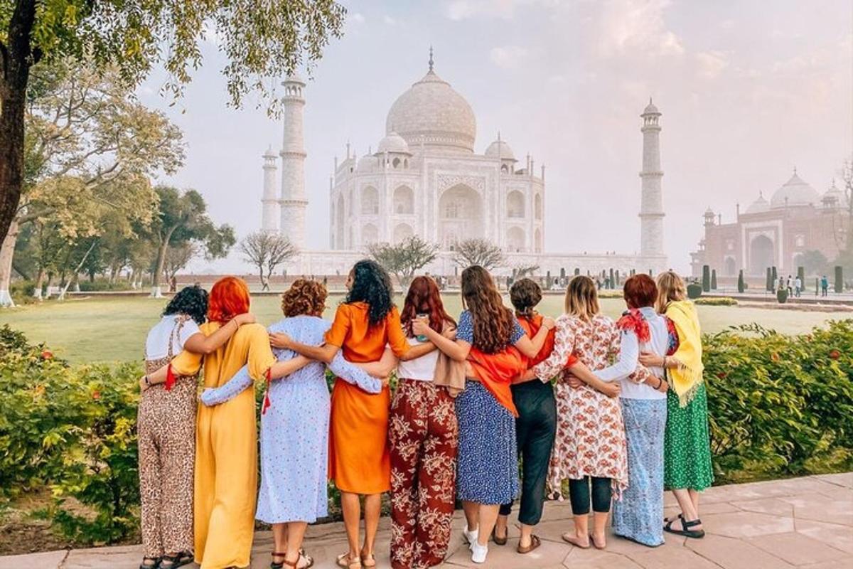 a group of women standing in front of the taj mahal