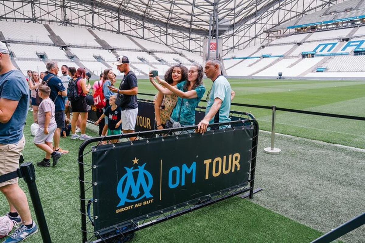 a group of people standing around a sign at a stadium
