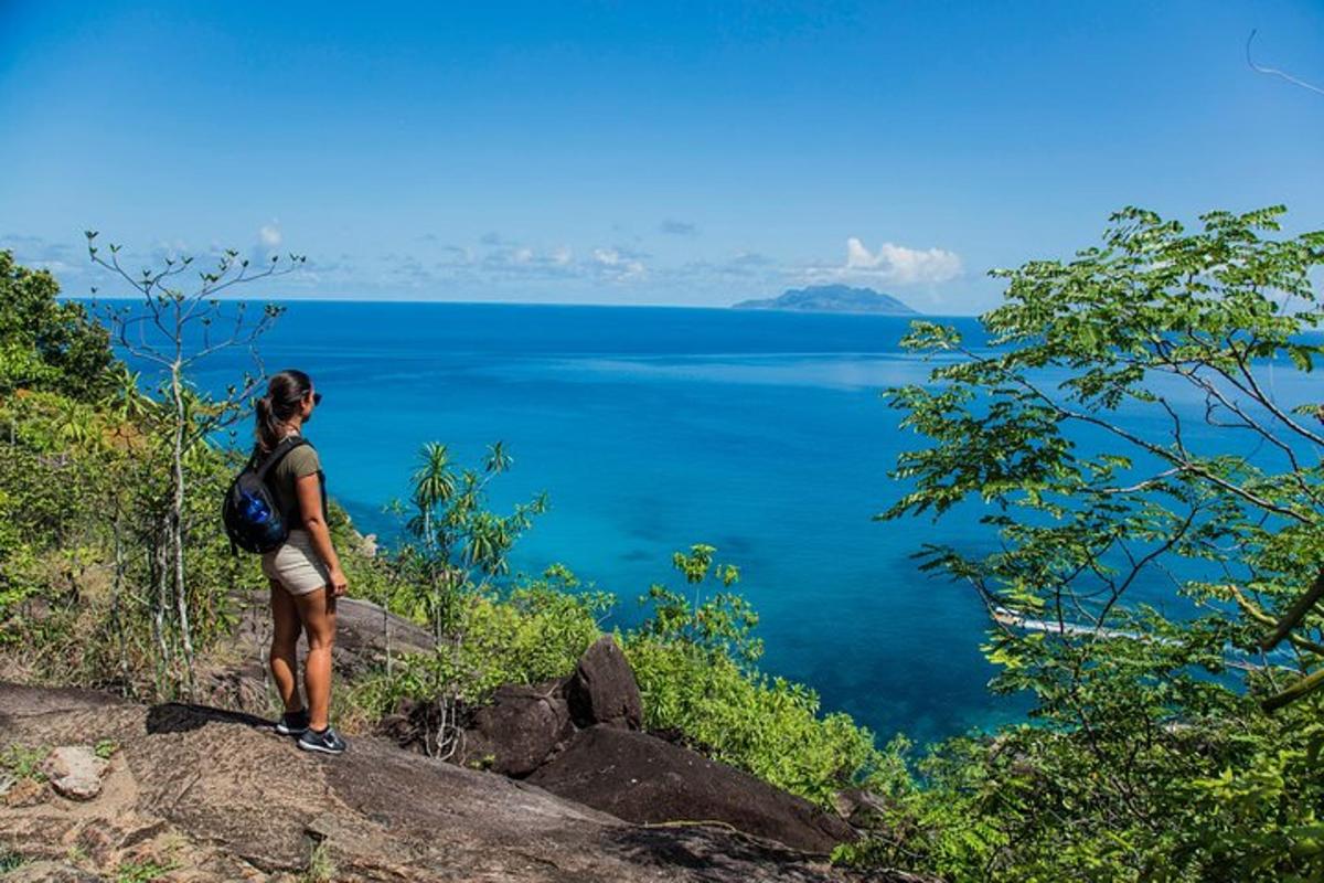 a woman standing on top of a hill overlooking a lake