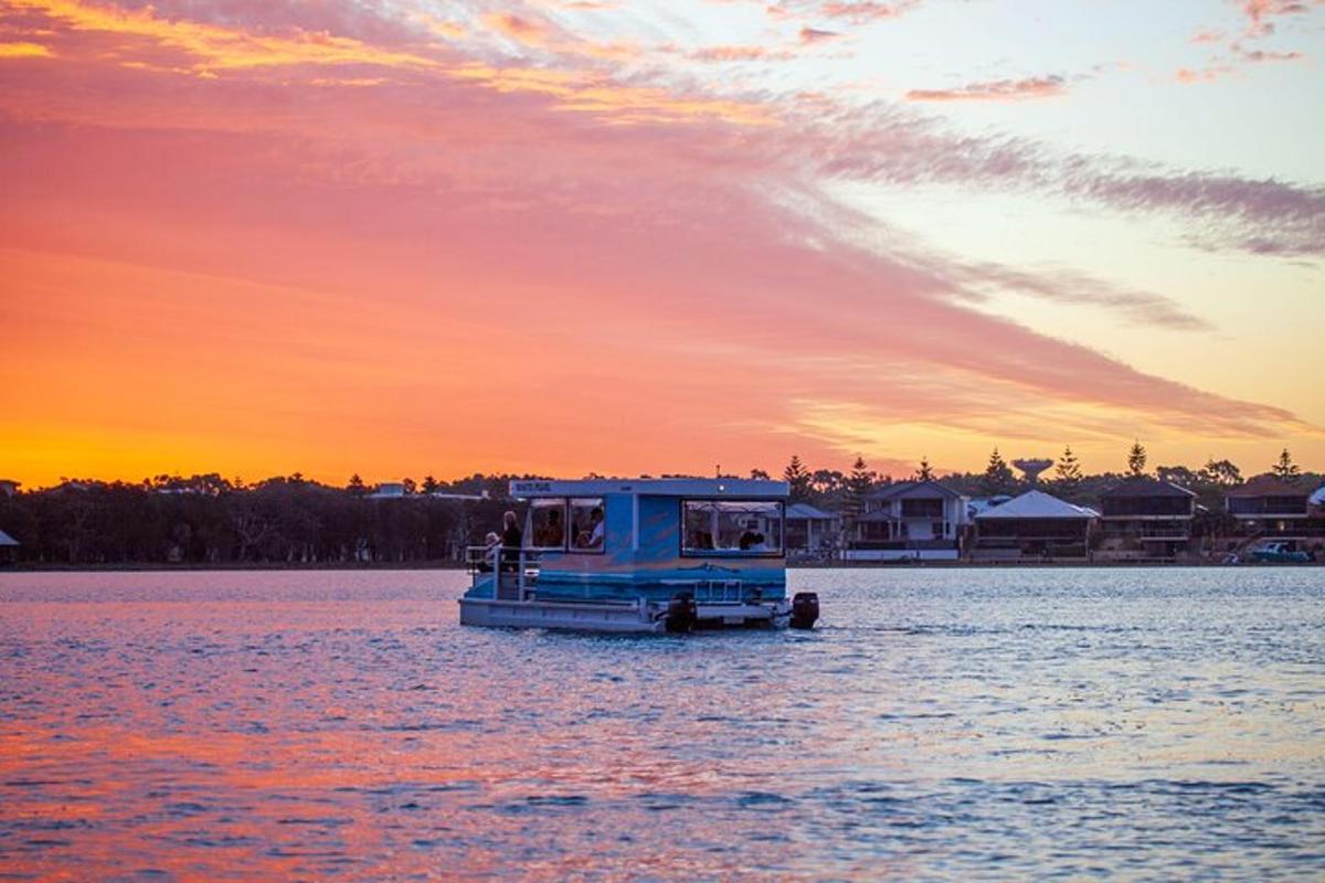 a blue boat in the water at sunset