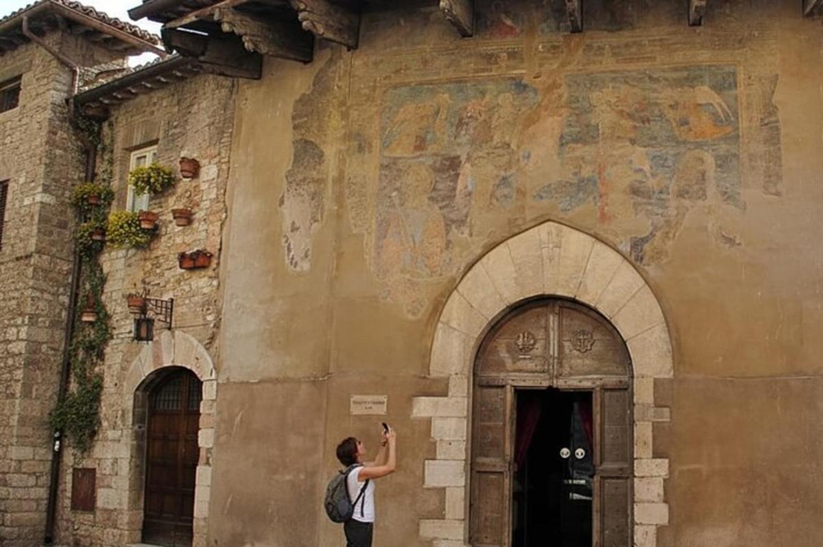 a man standing in front of a building with a painting on it