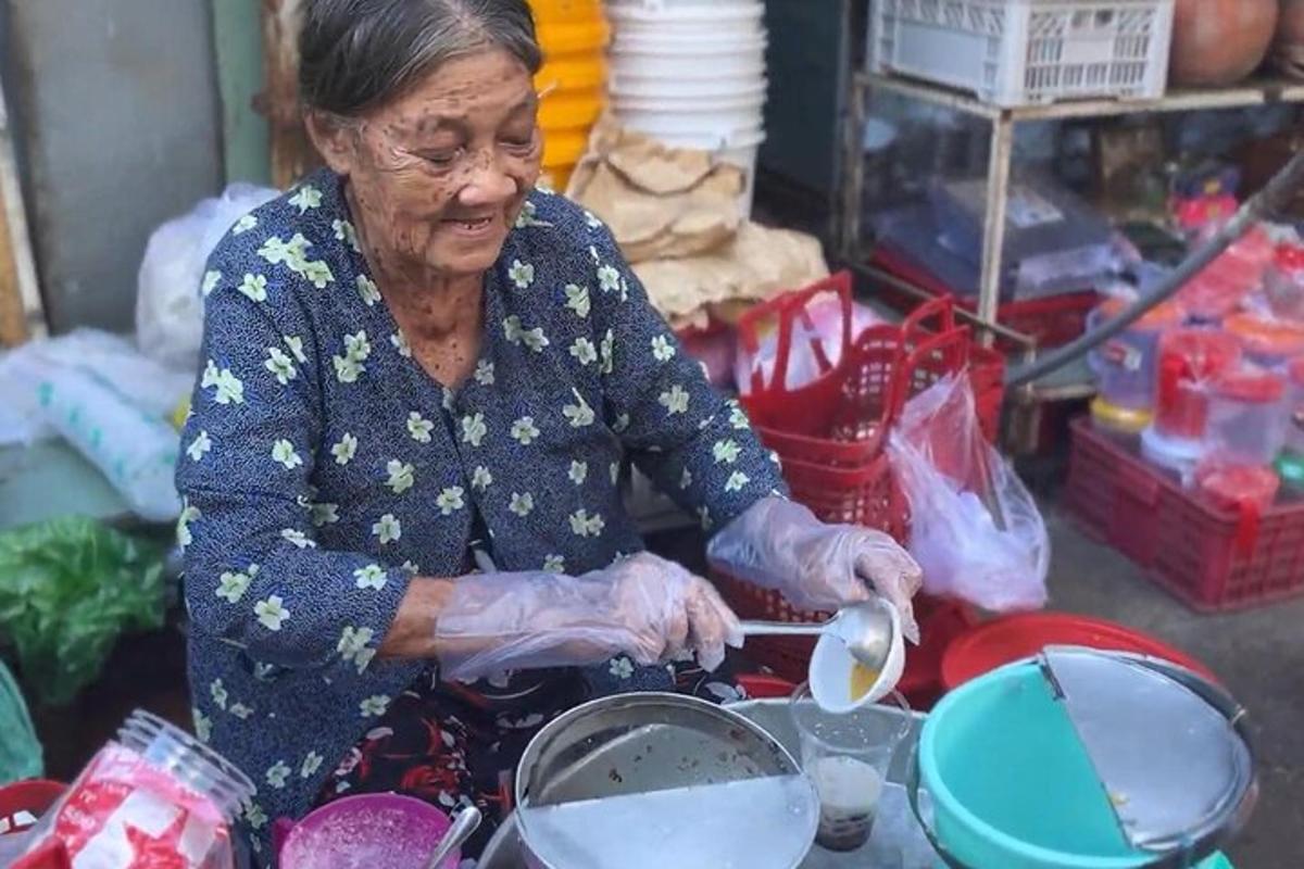 một người phụ nữ lớn tuổi đang nấu thức ăn trong nồi