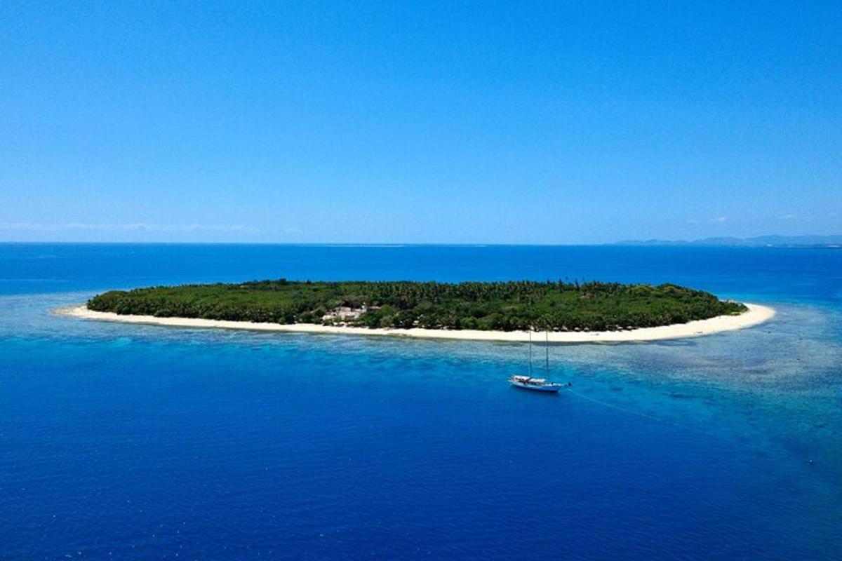 an island with a boat in the middle of the ocean