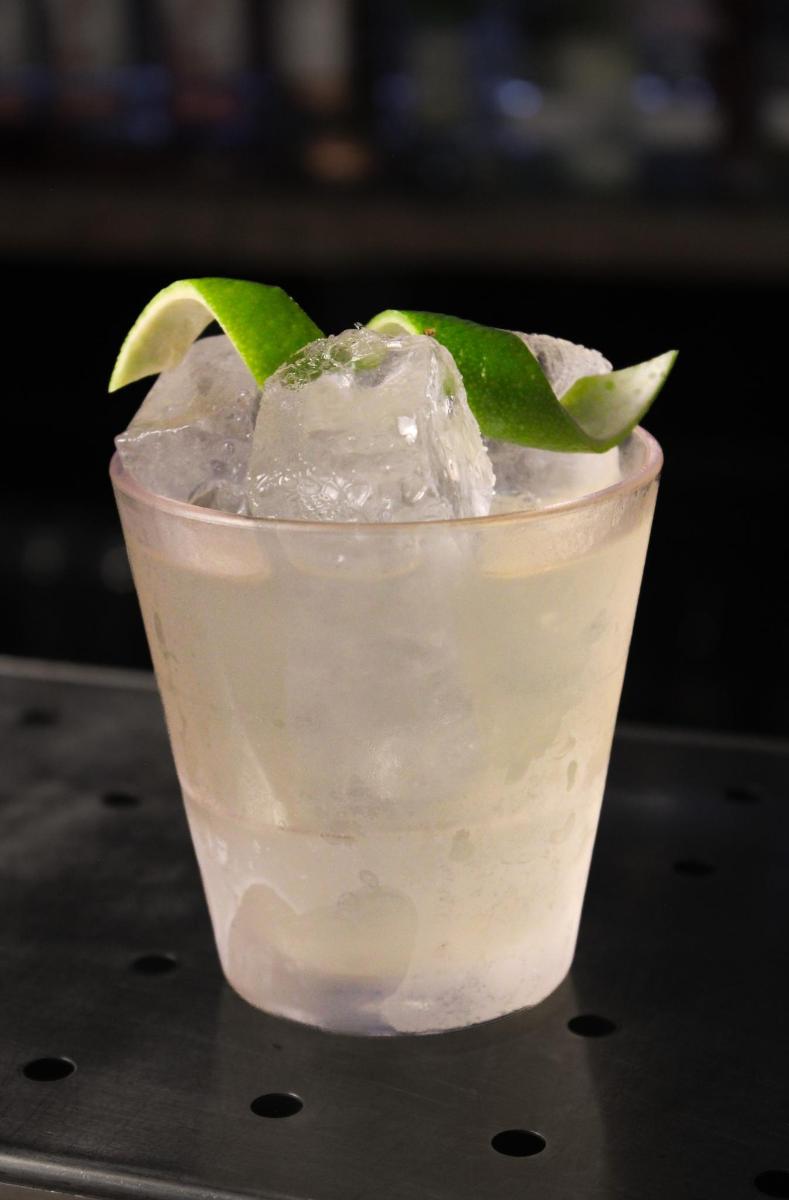 桌上放着一杯加冰和青柠的饮料