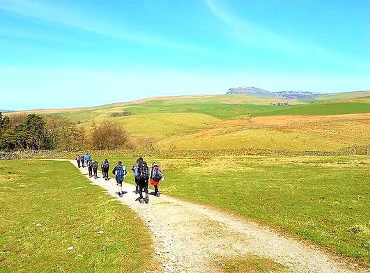 a group of people walking down a dirt road