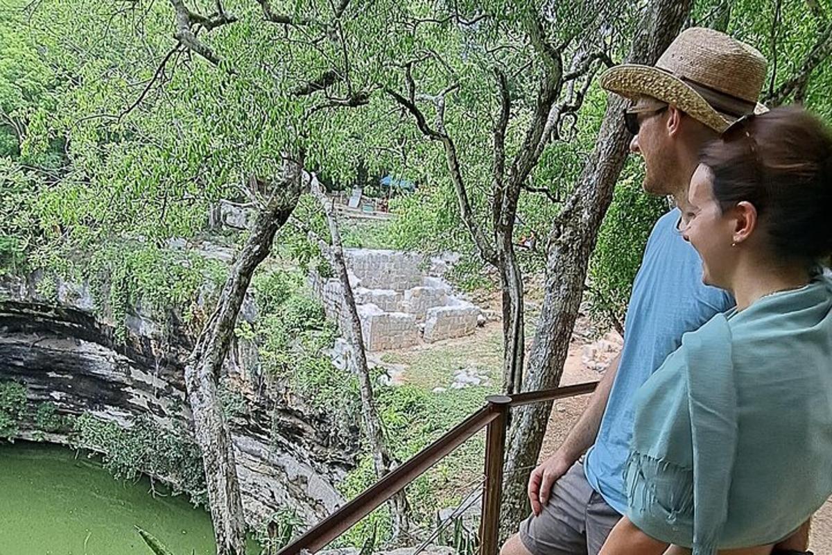 a man and woman sitting on a railing looking at a river