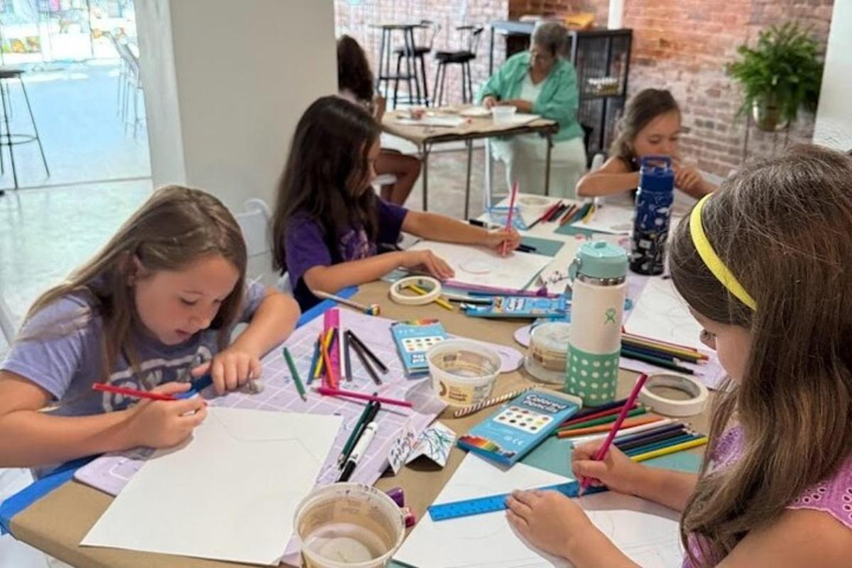 一群孩子坐在桌边画画