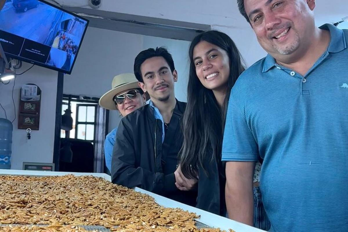 a group of people standing next to a table of food