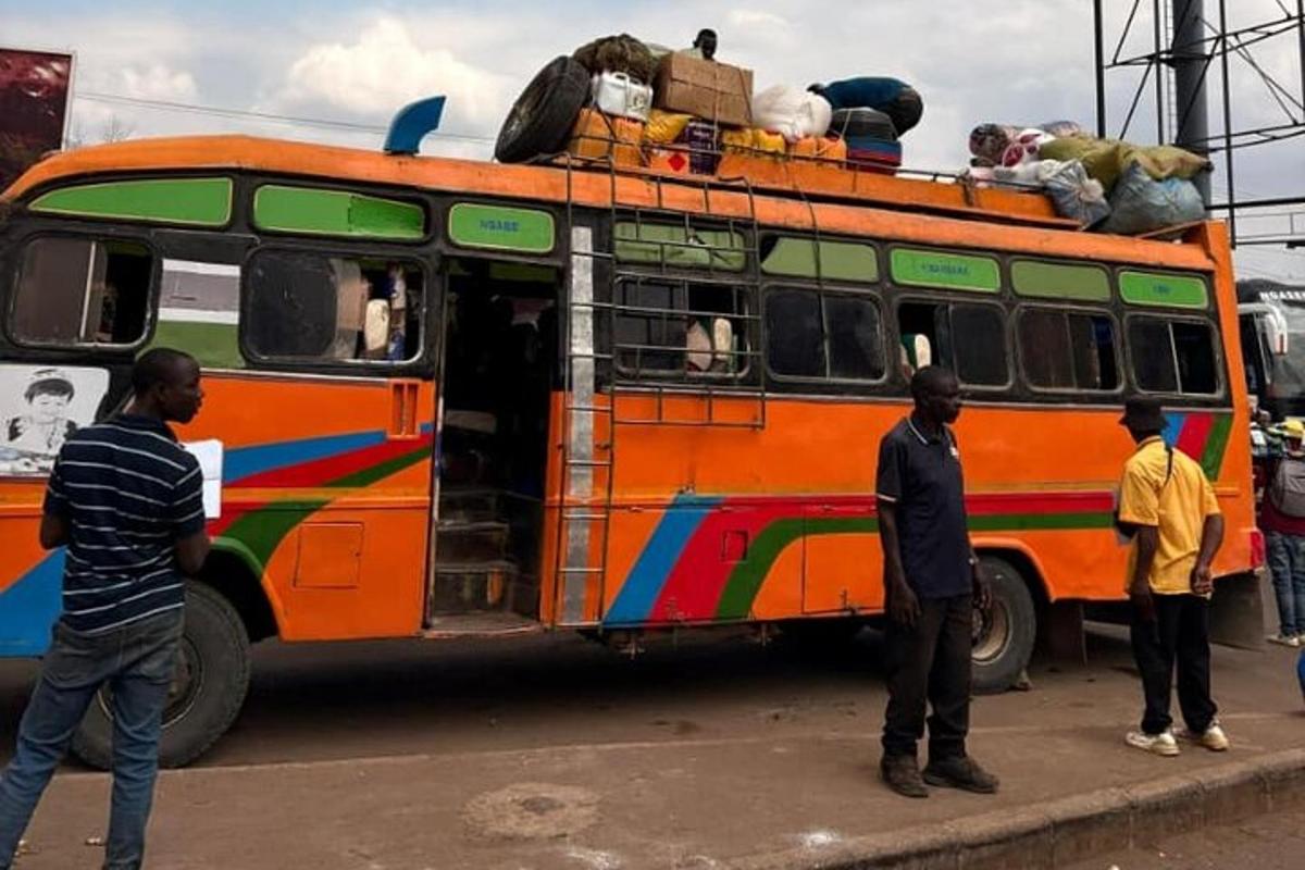 a group of men standing around a colorful bus