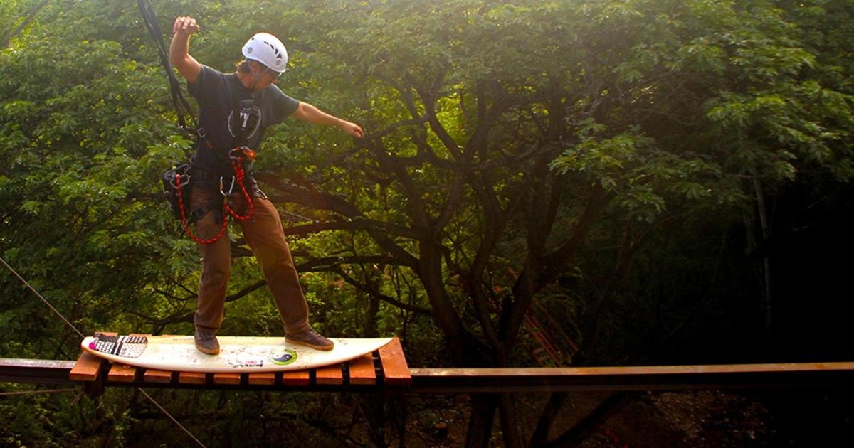 a man standing on a surfboard on a board
