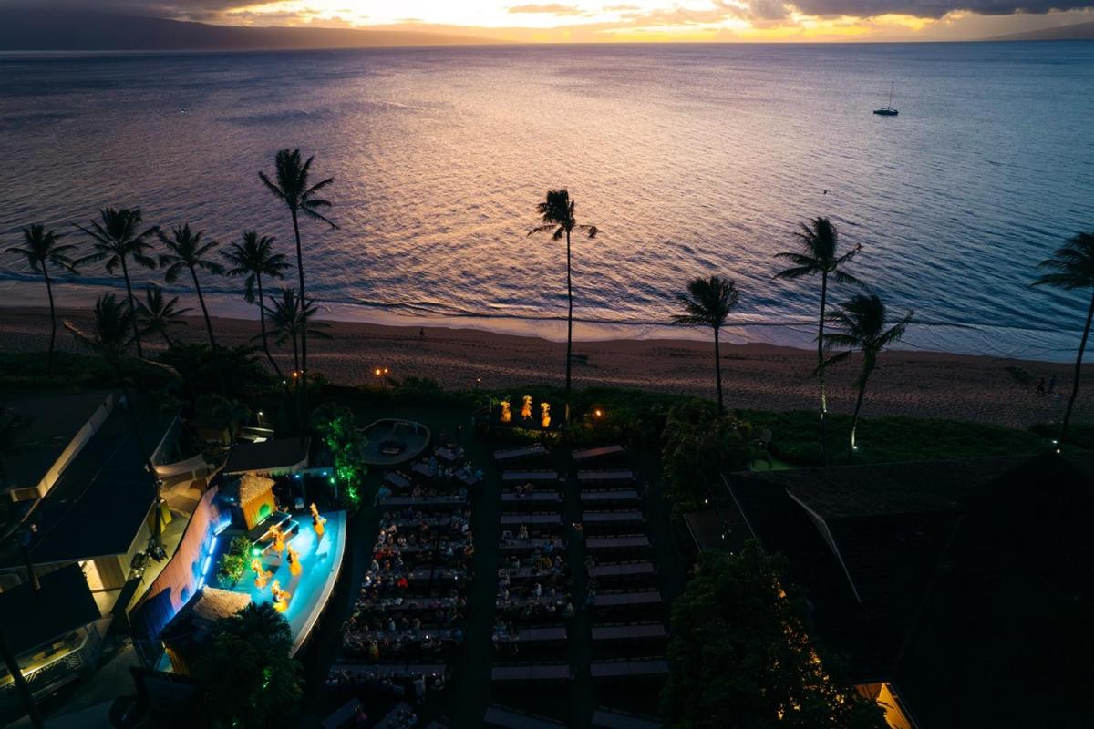 a view of a beach at sunset with palm trees