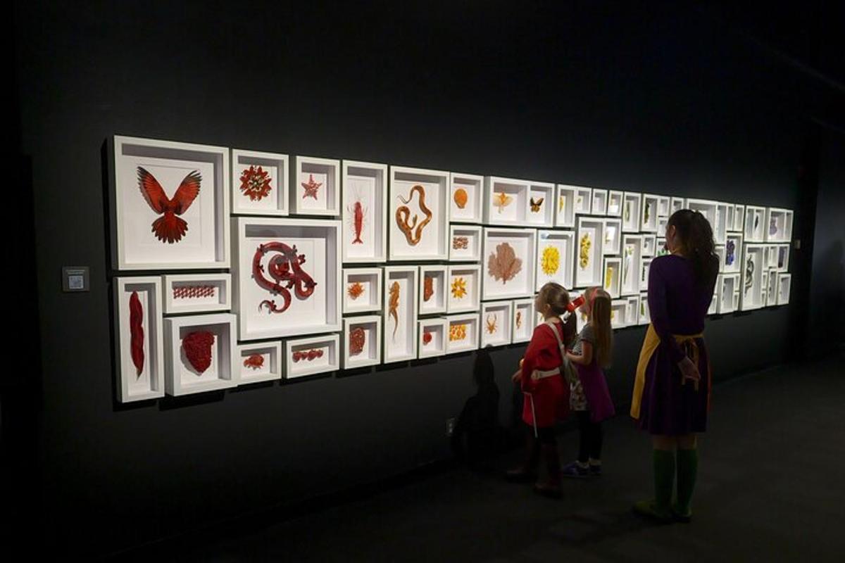 a woman and a child looking at art on a wall