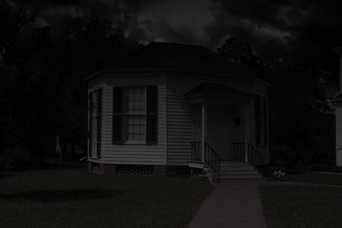 a black and white photo of a house at night