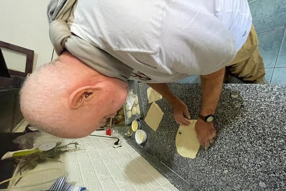 a man is standing on a counter cutting something