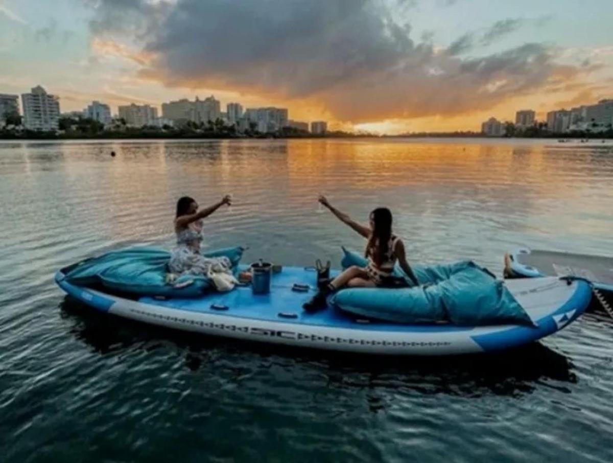 two women are sitting on anlatable raft on the water