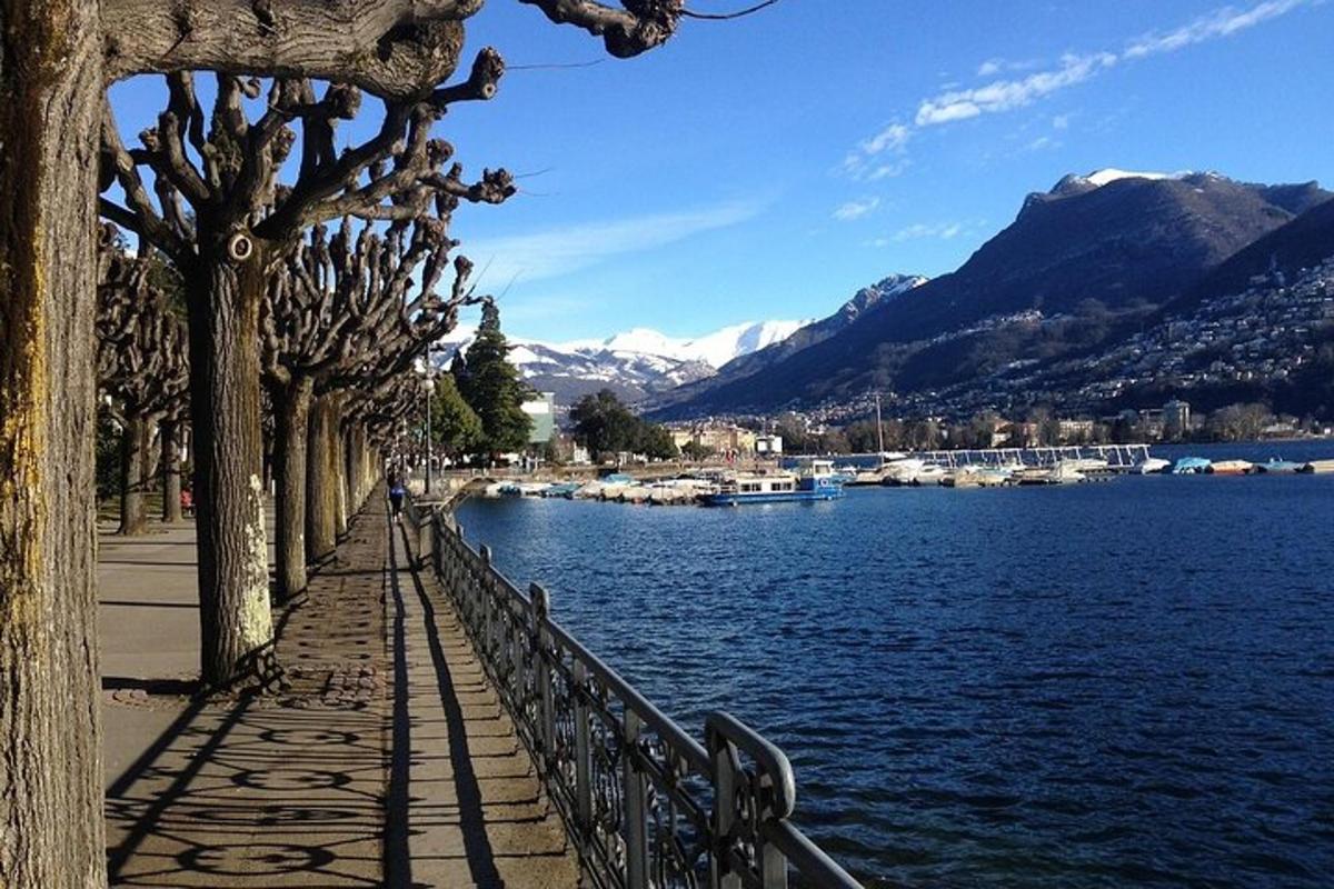 chodník vedle vodní plochy s horami