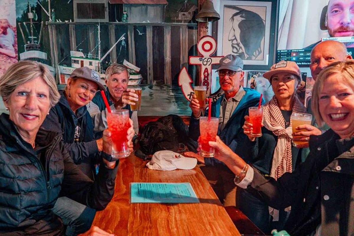 a group of people sitting around a table holding up drinks