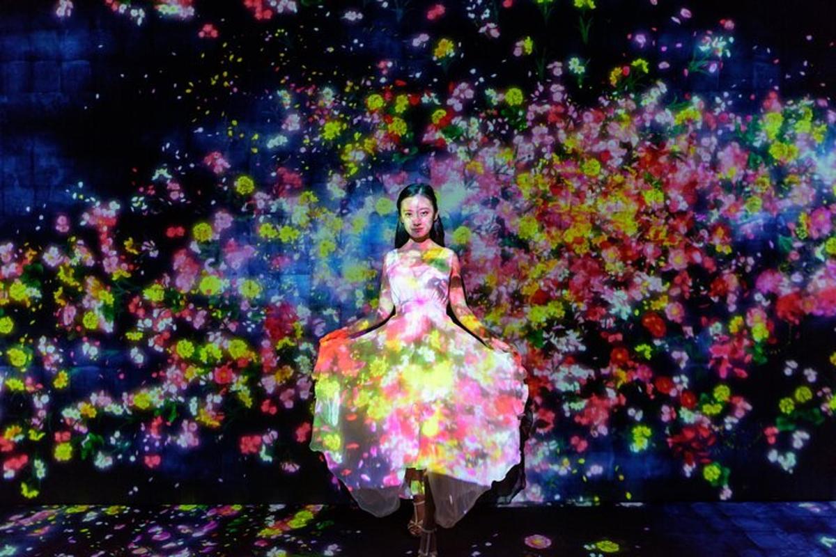 Una mujer con un vestido colorido frente a una multitud.
