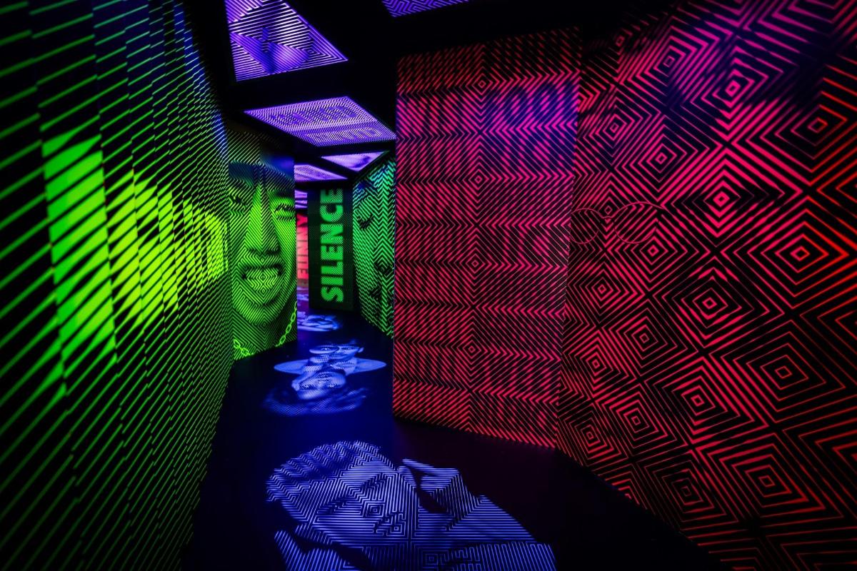 a room with a colorful wall with a bottle in front