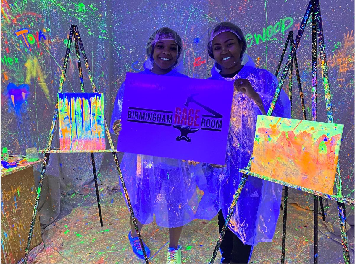 เด็กผู้หญิงสองคนถือป้ายสีม่วงในนิทรรศการภาพวาด