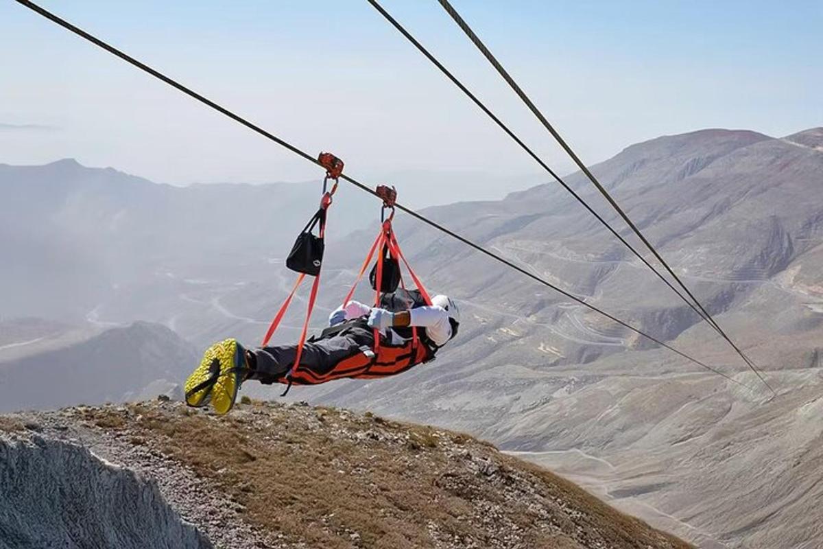 a person is hanging on a zip line on a mountain
