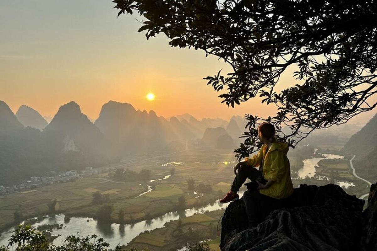 a person sitting on top of a mountain watching the sunset