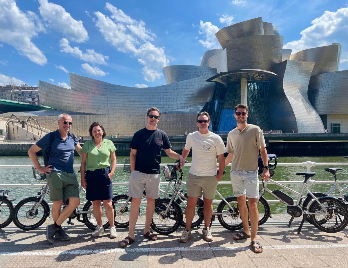 a group of people standing in front of a building with bikes
