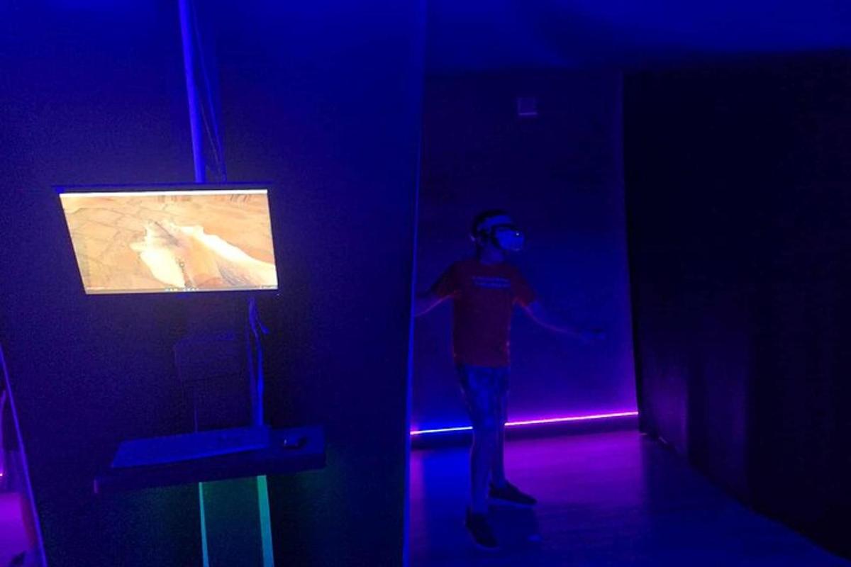 a man standing in a dark room with a tv
