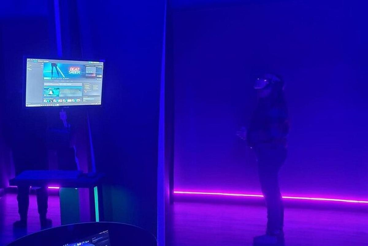 a person standing in a dark room with a purple light
