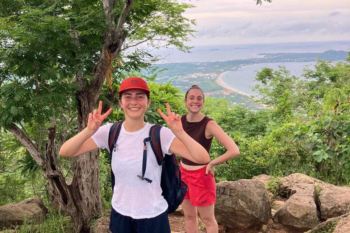 two people standing on a mountain with their hands up