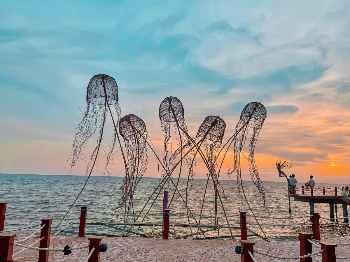 a sculpture on the beach at sunset