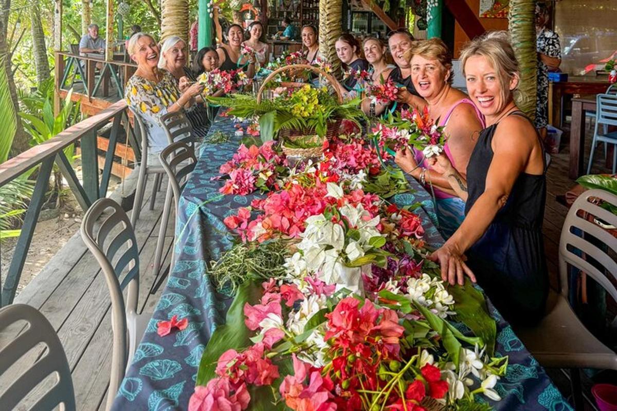 skupina žen sedících u dlouhého stolu s květinami